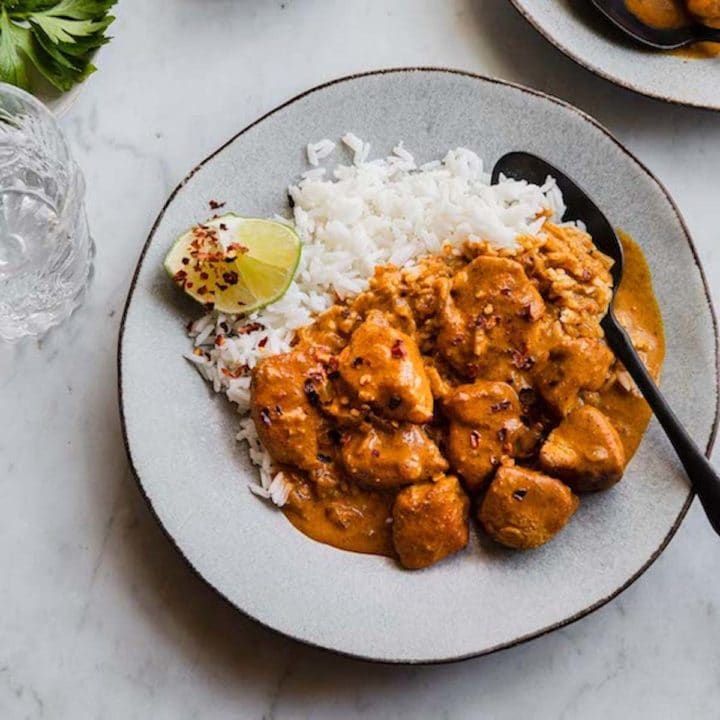 A plate of curry chicken and rice.