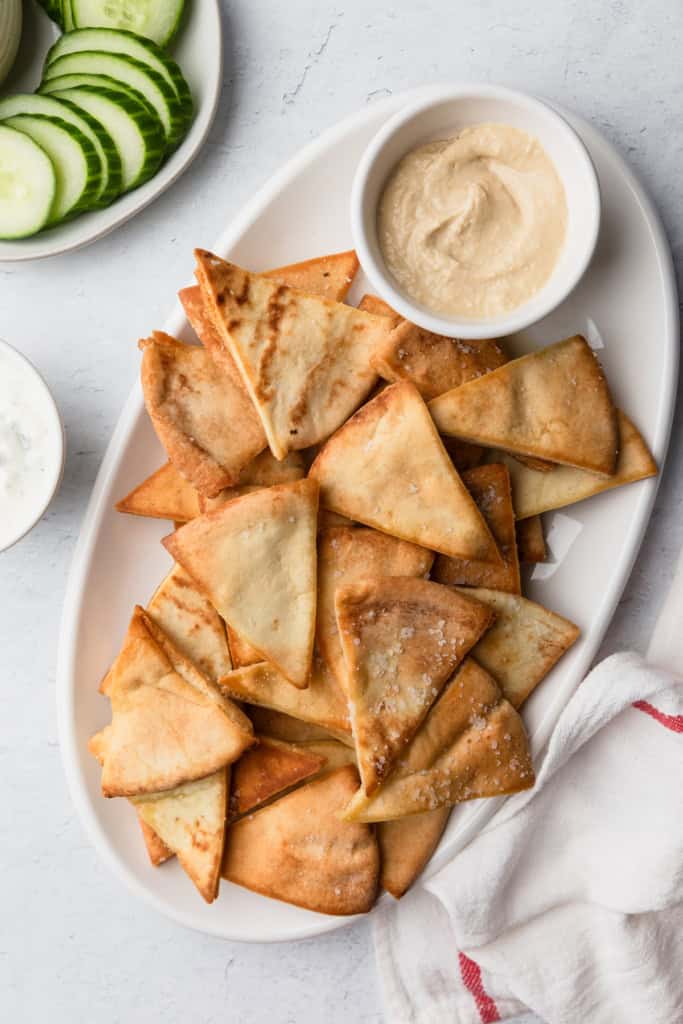 Air fryer pita chips with some cucumbers.