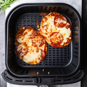 Air fryer naan pizza in the air fryer basket.