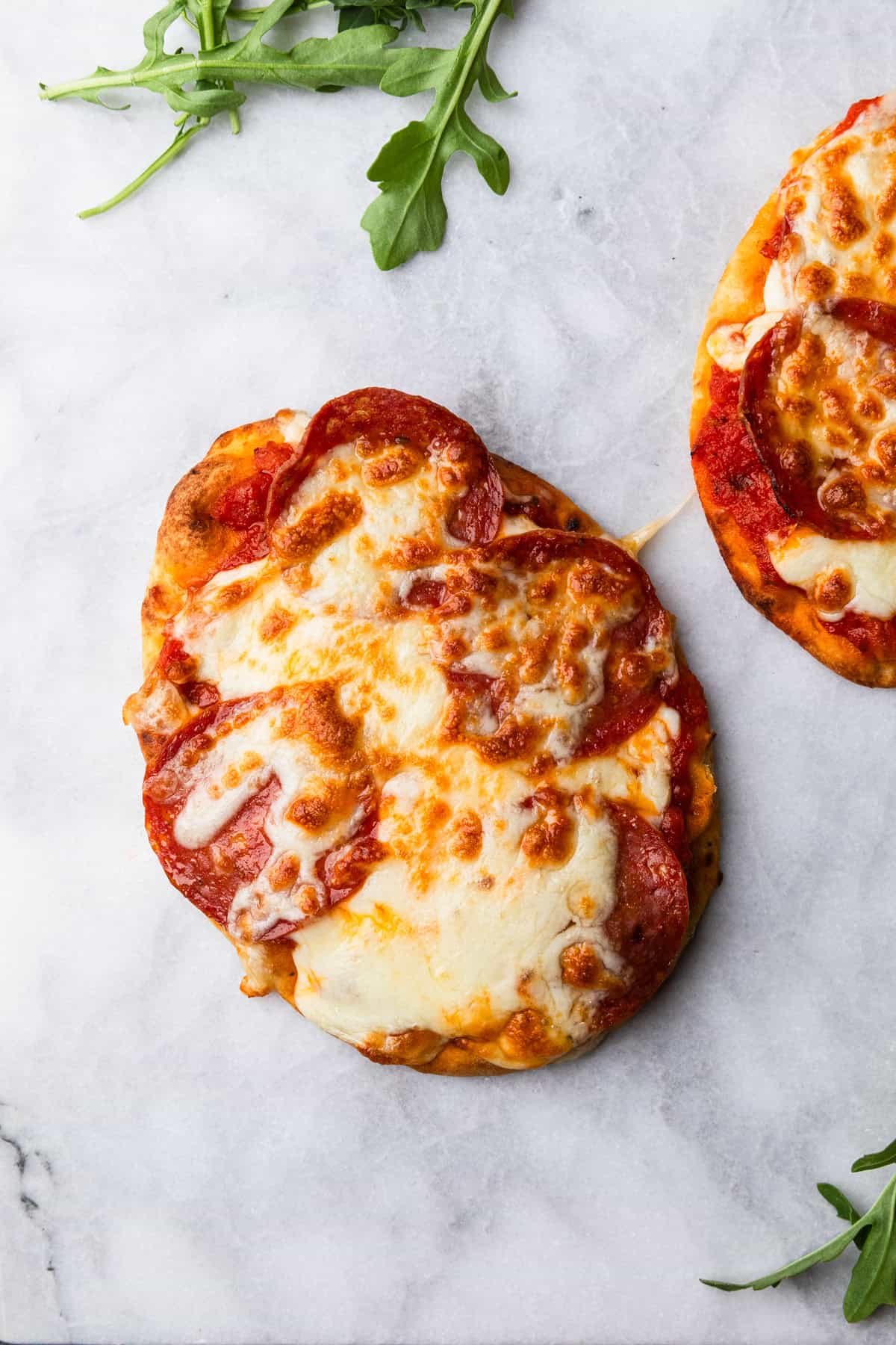 Air fryer naan pizza on a marble board.