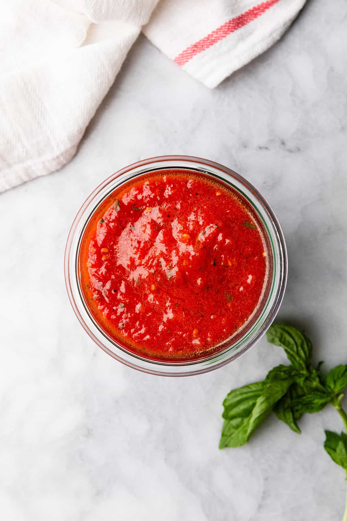 The completed pizza sauce in a glass container.