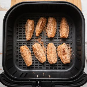 Apple slices in an air fryer basket.