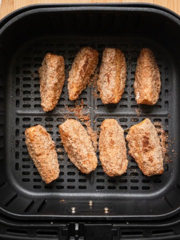 Apple slices in an air fryer basket.