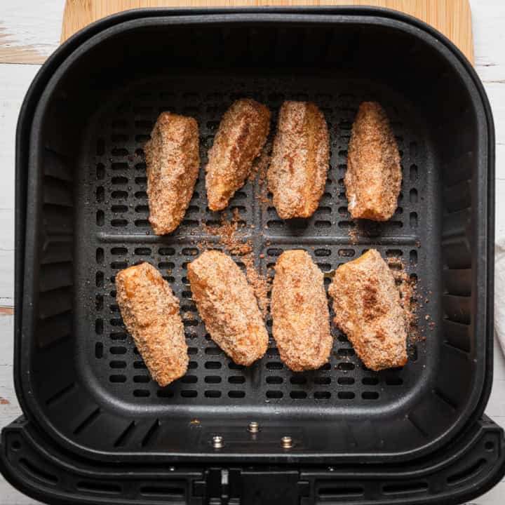 Apple slices in an air fryer basket.