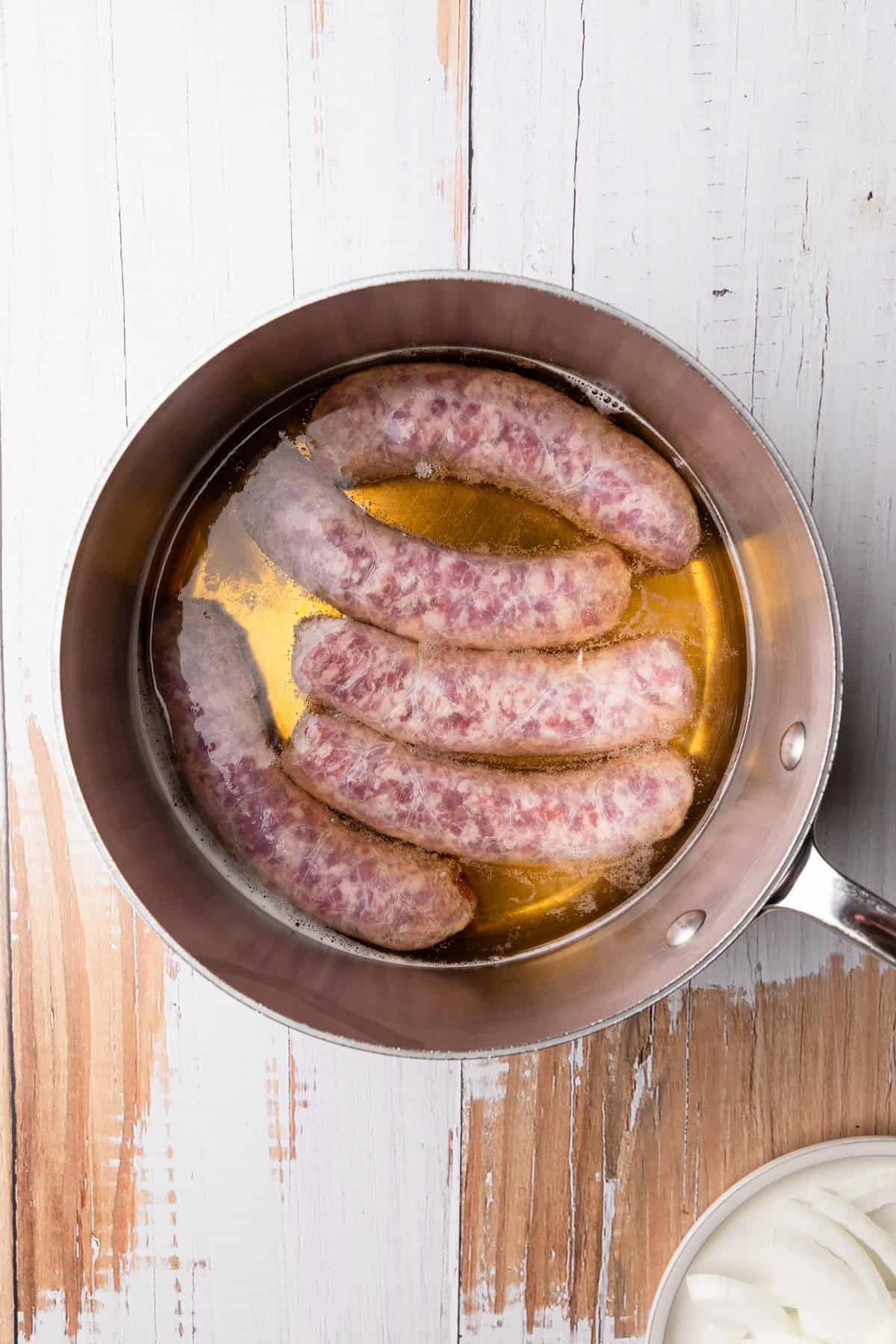 Cooking raw bratwurst in beer.