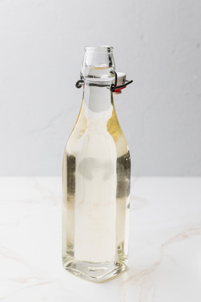 A glass bottle filled with simply syrup.