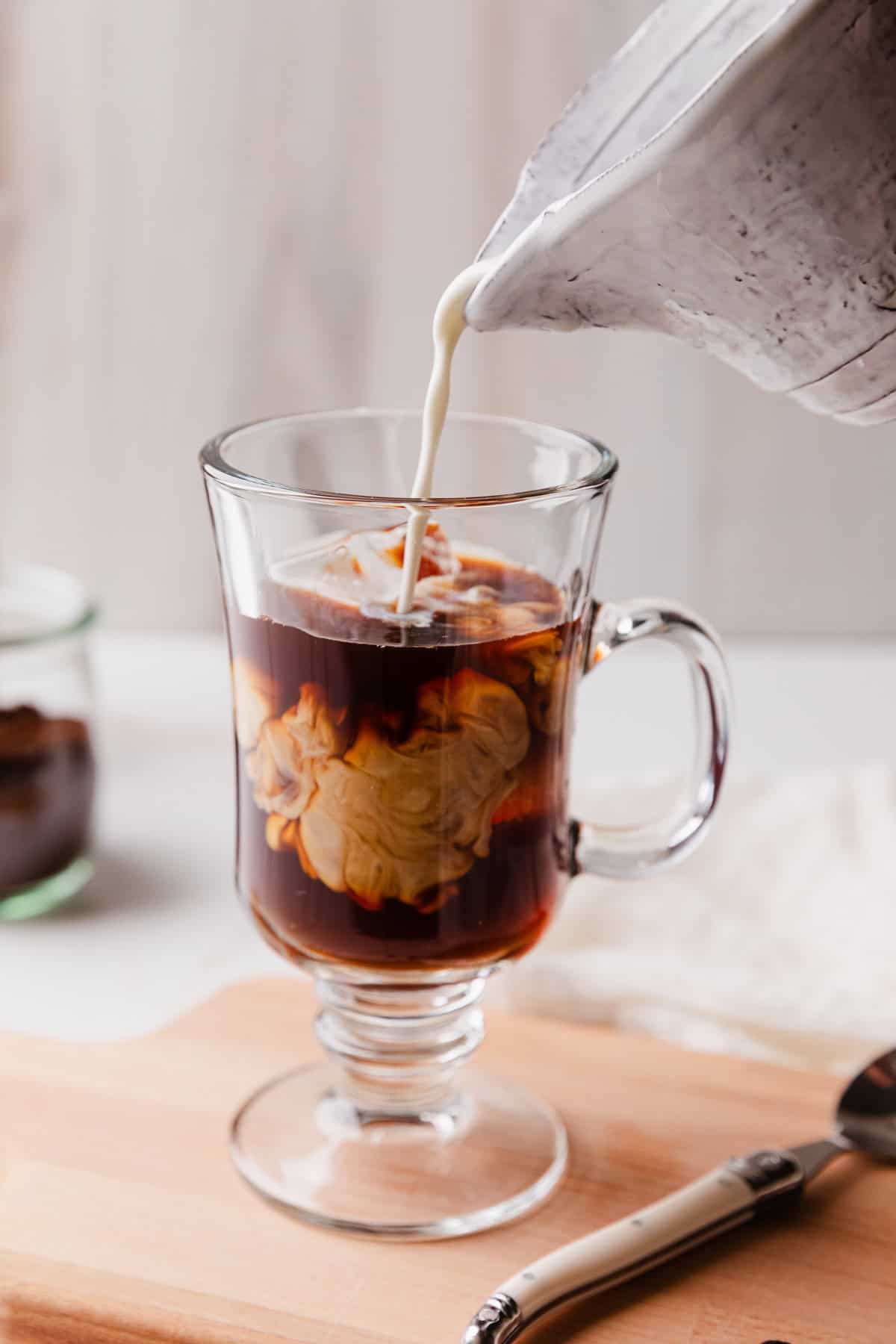 Adding dairy to an iced coffee.