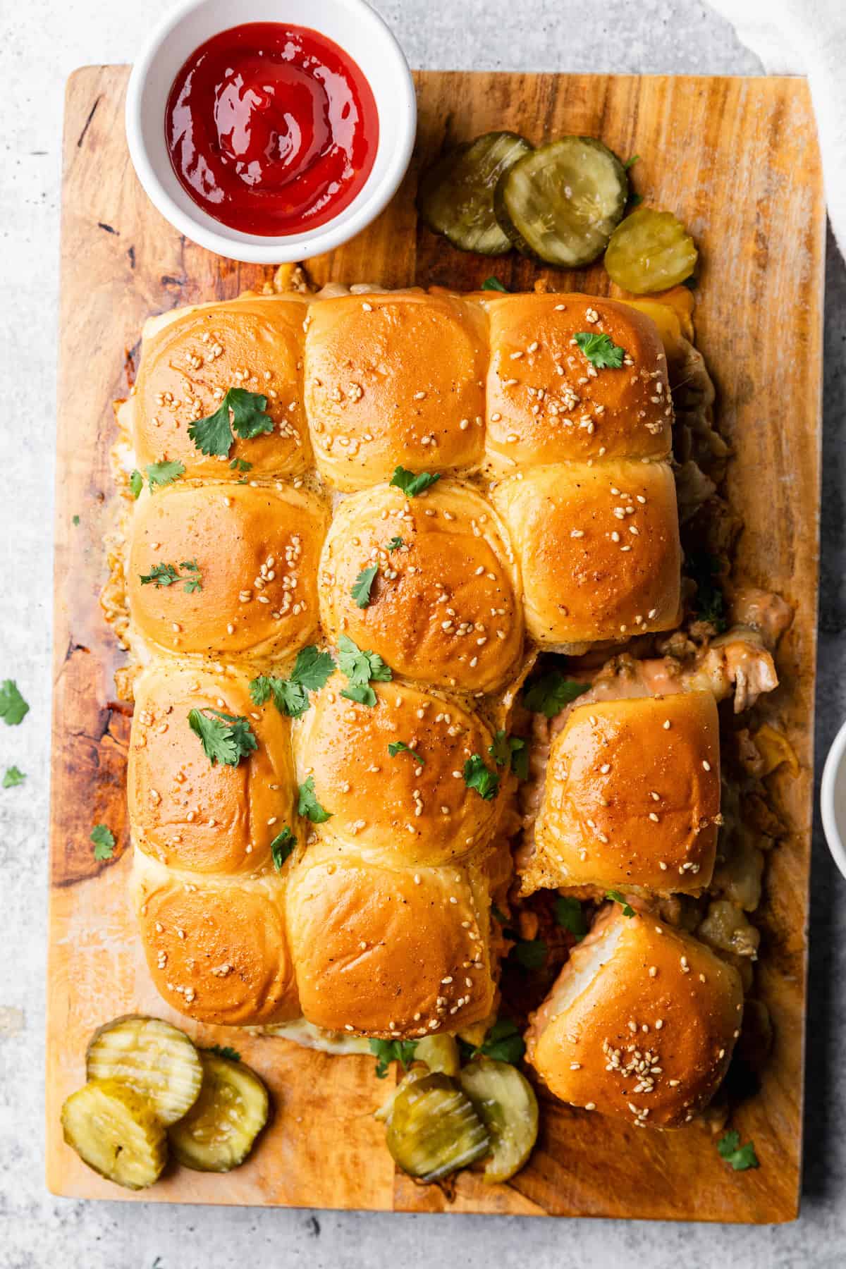 Turkey burger sliders on a cutting board with a side of ketchup.