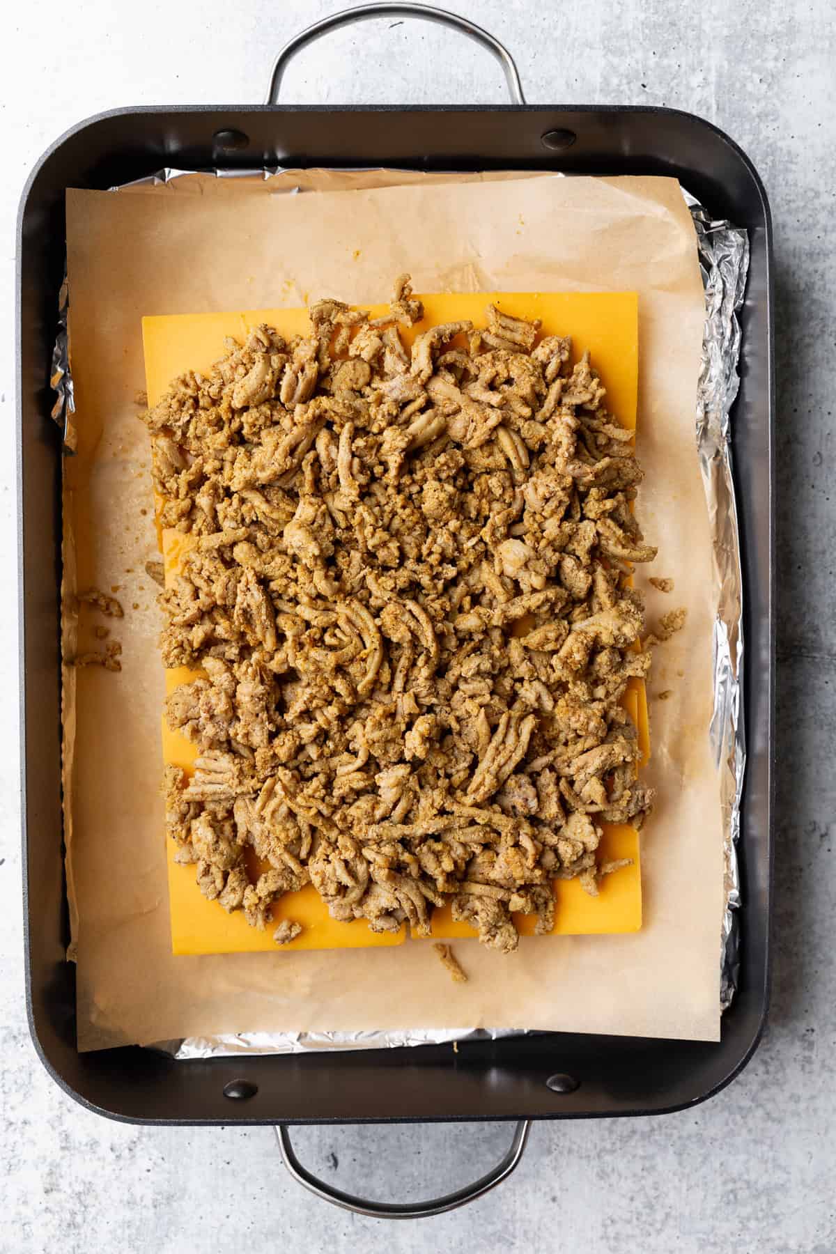 Cooked ground turkey layered on cheese.