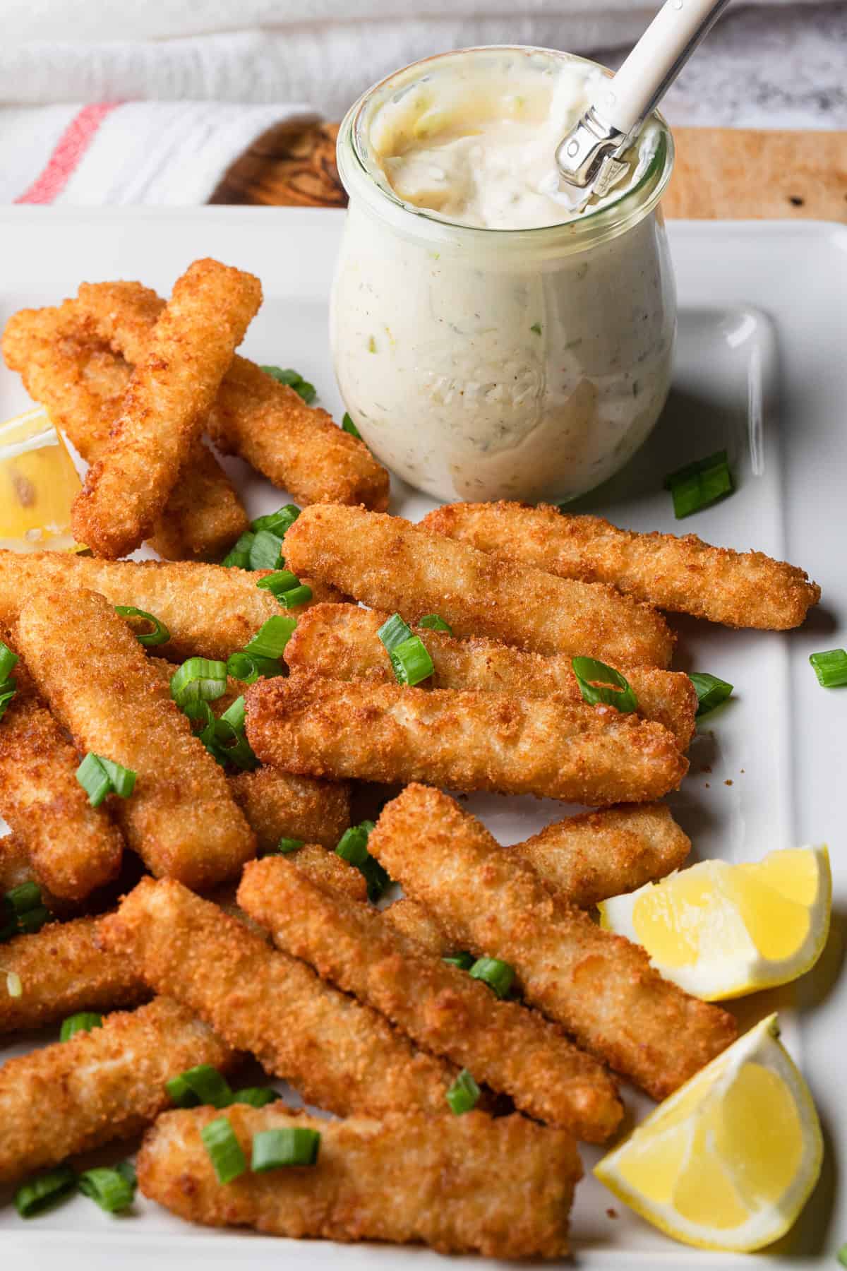 A plate with fish sticks and tartar sauce.