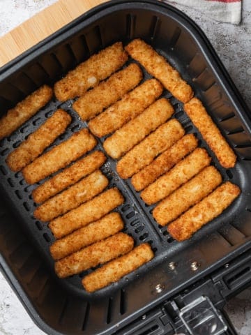 Air fryer fish sticks in the basket.