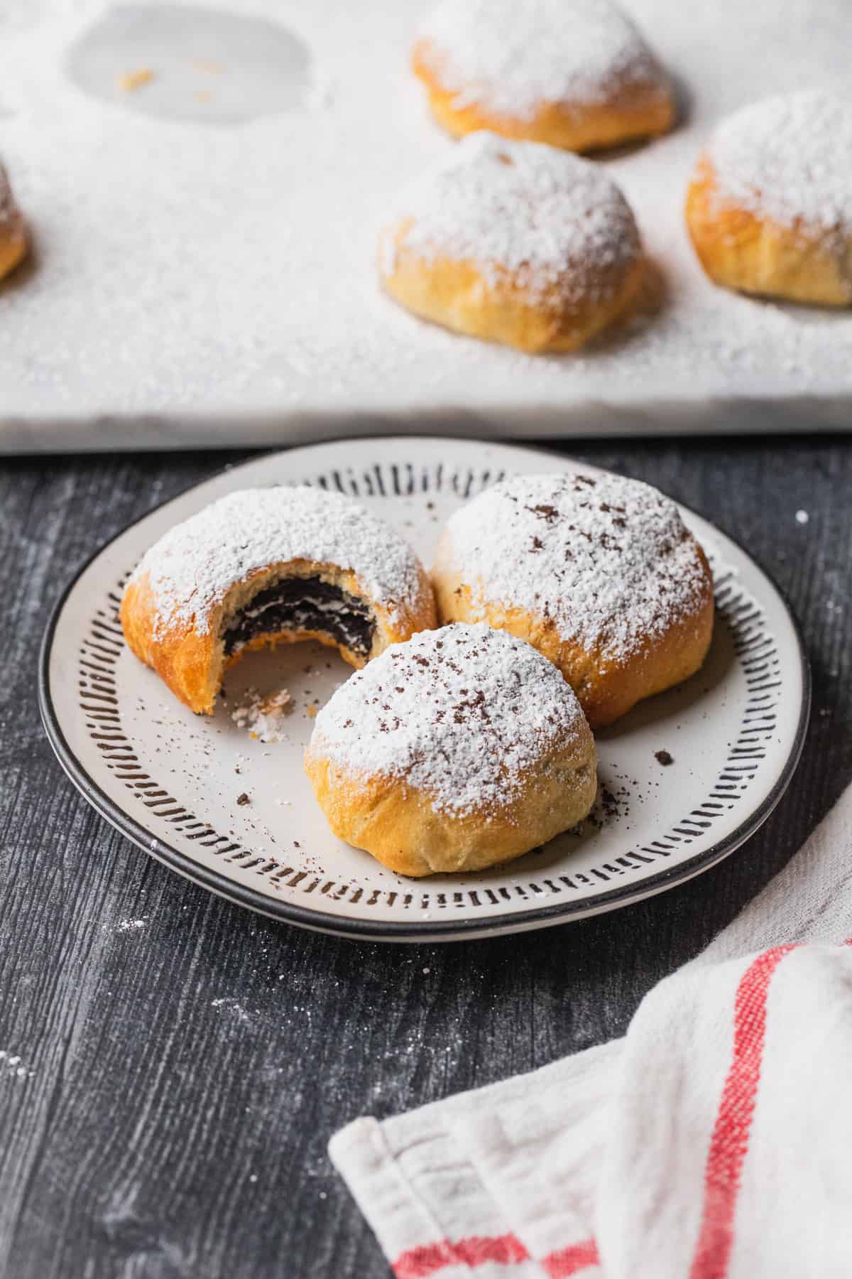 Air fryer oreos dusted with powdered sugar and on a plate.