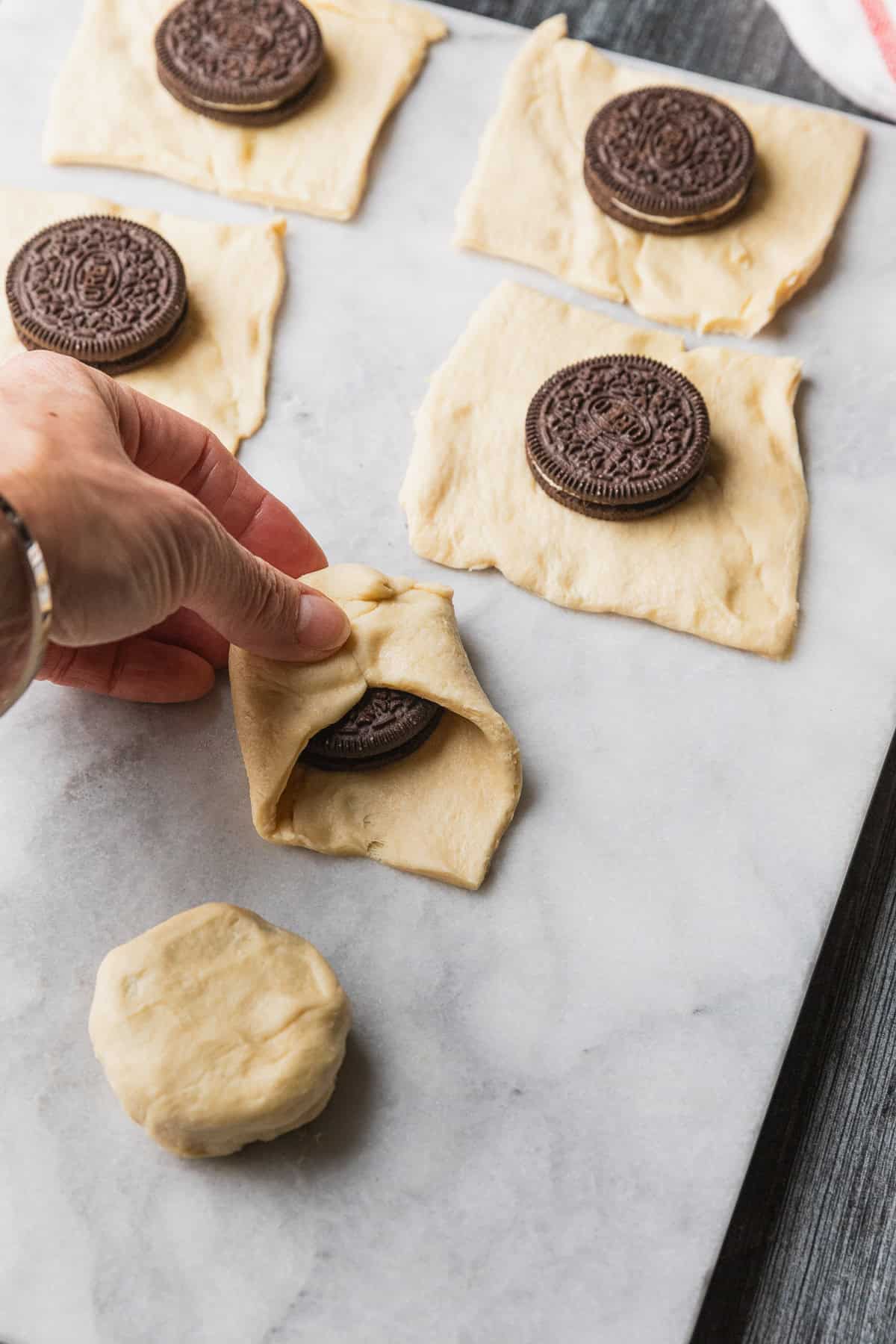 Wrapping dough over cookies.