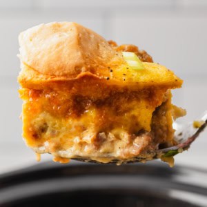 A piece of biscuits and gravy casserole over a crockpot.