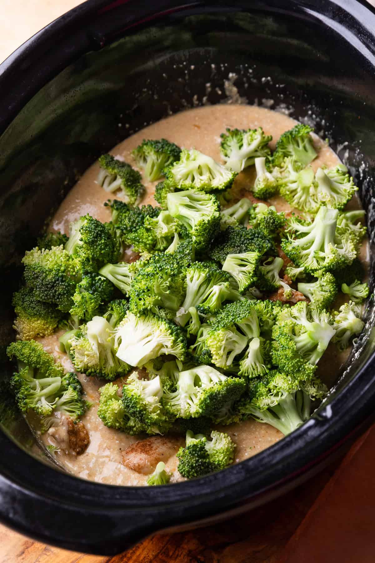 Broccoli added to a crockpot.