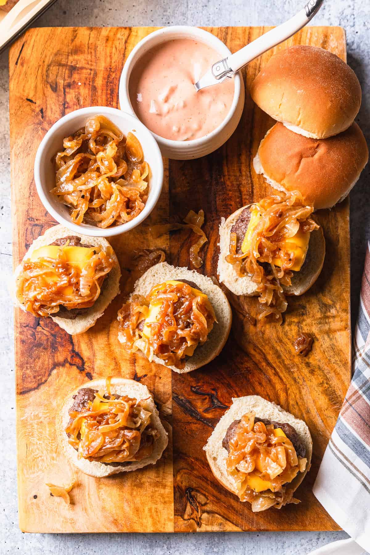 Sliders on buns with caramelized onions.