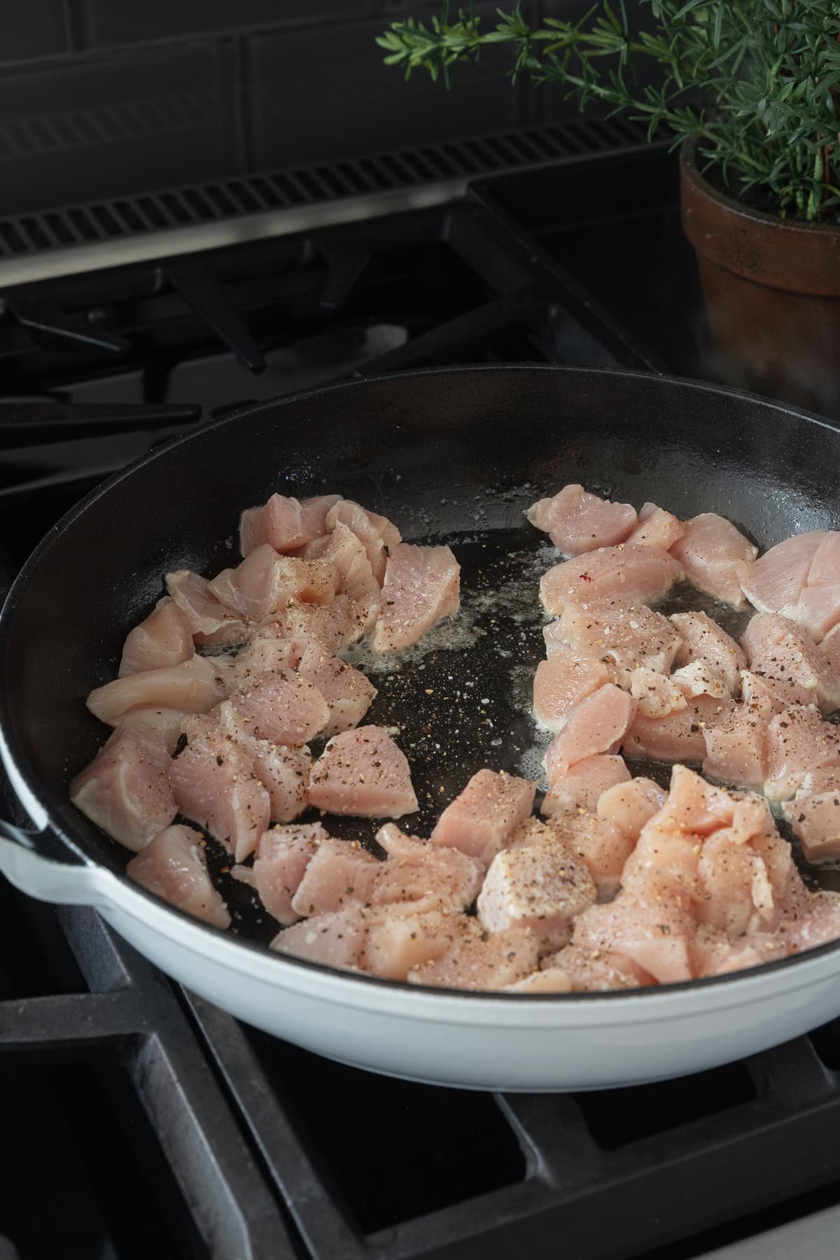 Raw chicken in a skillet.