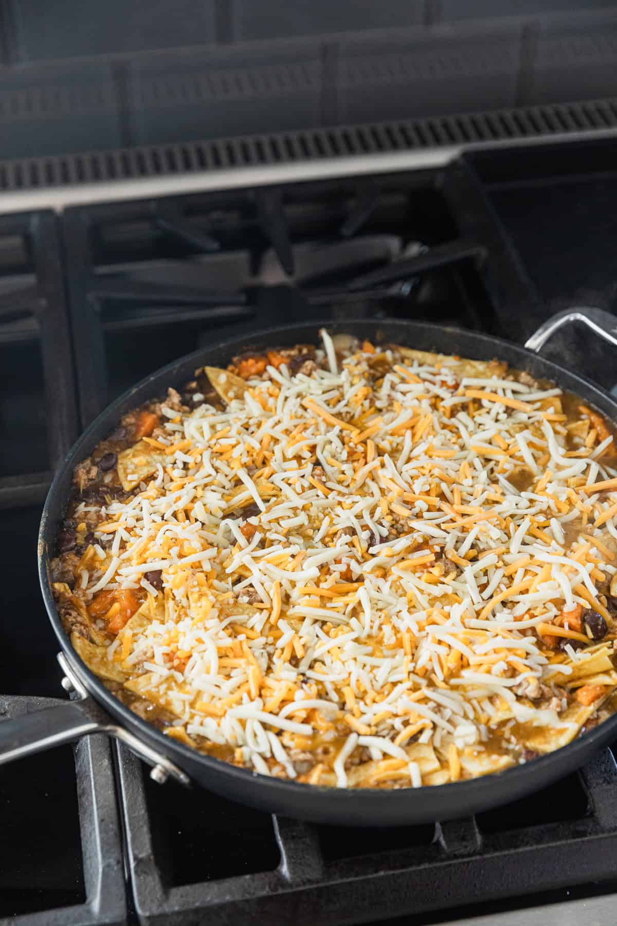 Shredded cheese added to skillet.