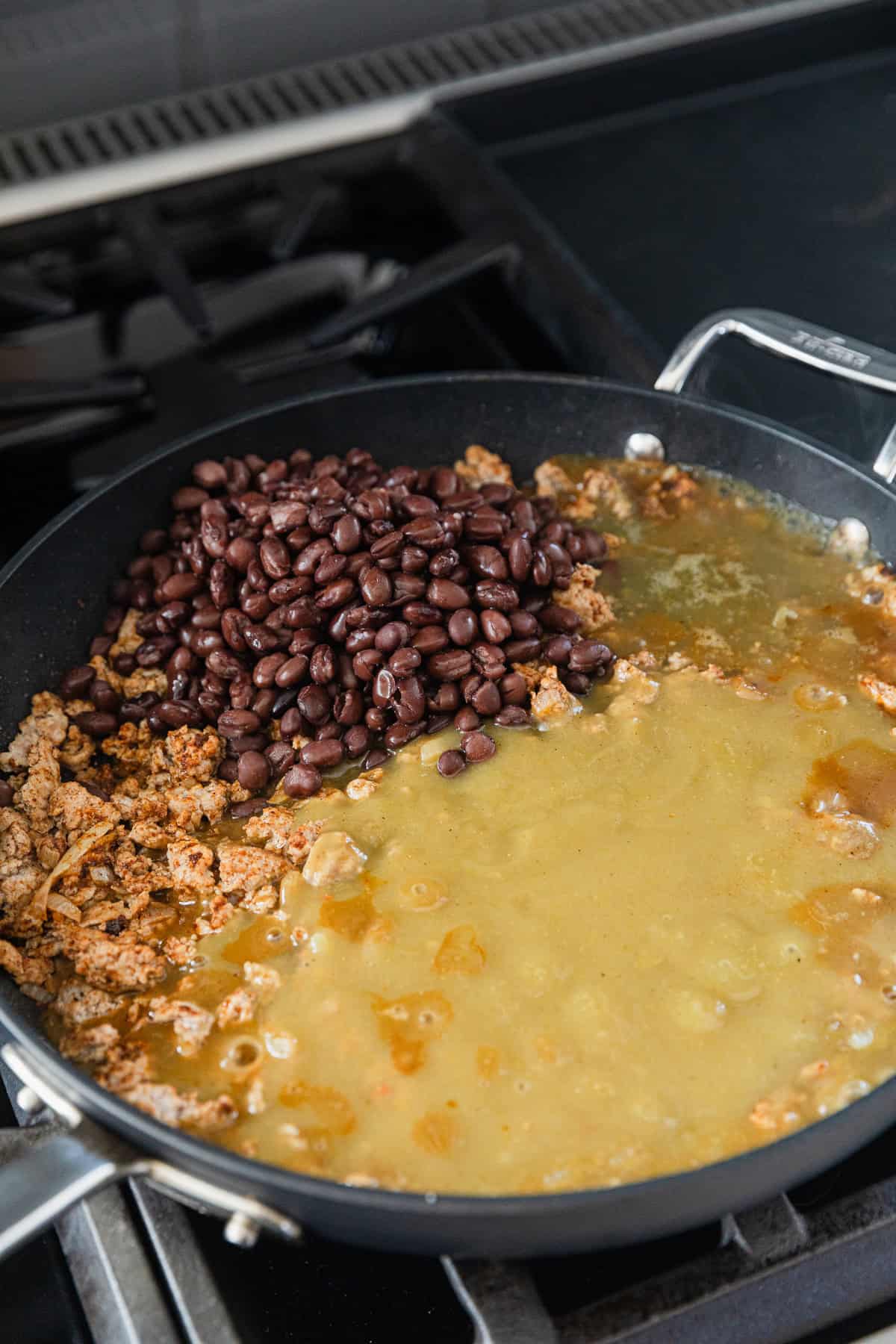 Adding sauces and beans to skillet.