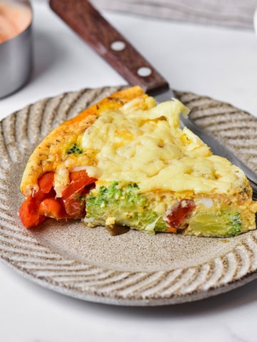 Healthy vegetable frittata wedge on a plate.