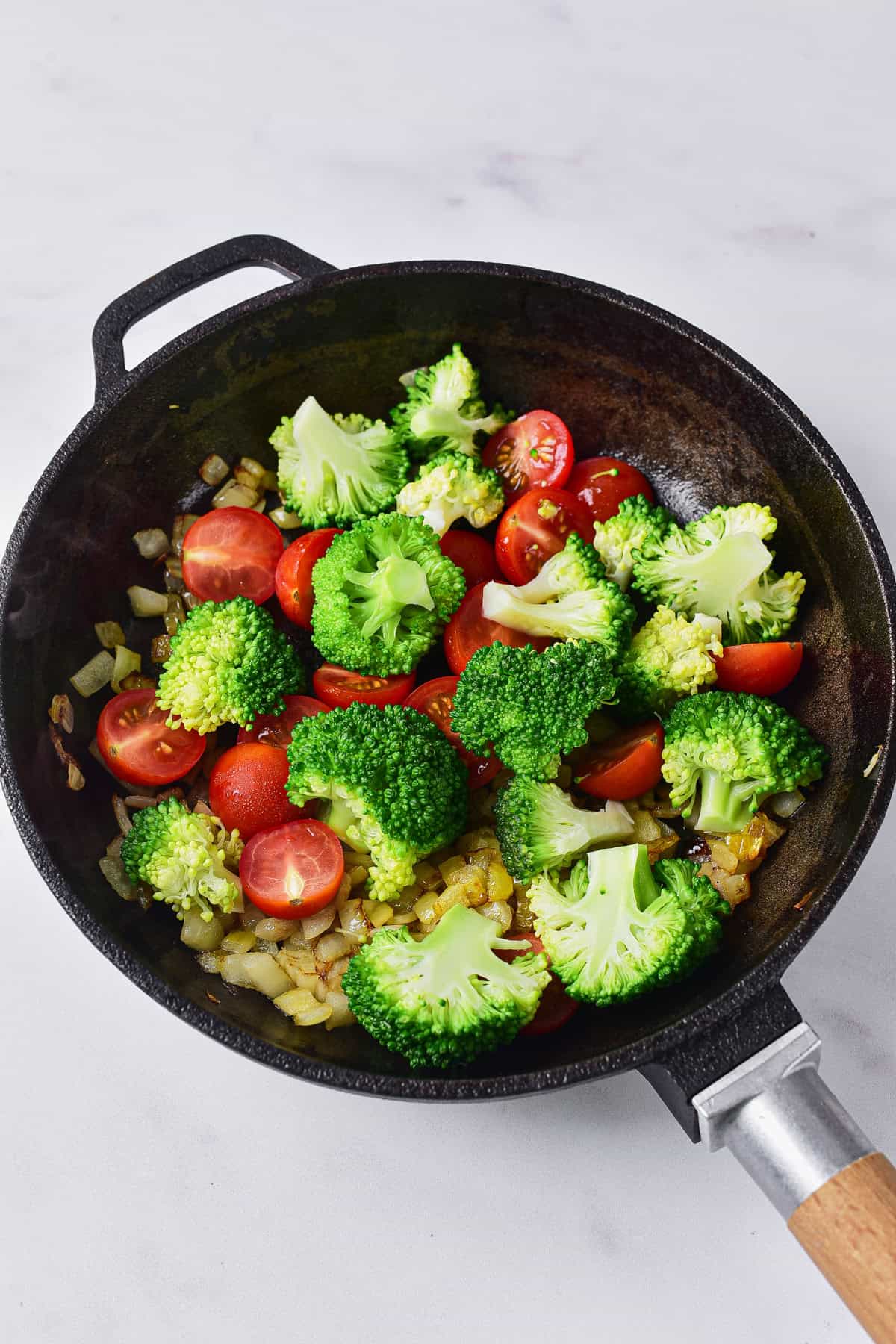 Cooking broccoli and cherry tomatoes.