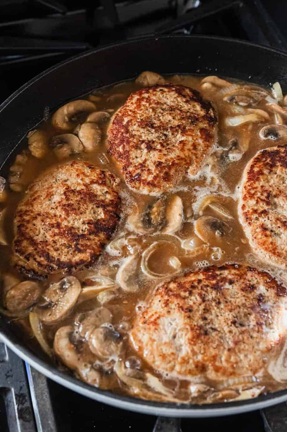 Simmering turkey patties in the gravy.