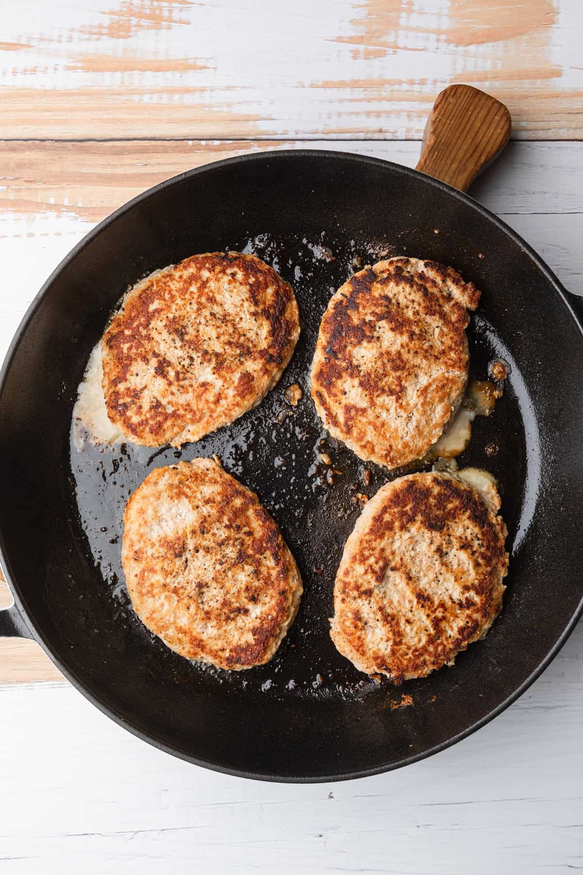 Cooked tukey patties in the skillet.