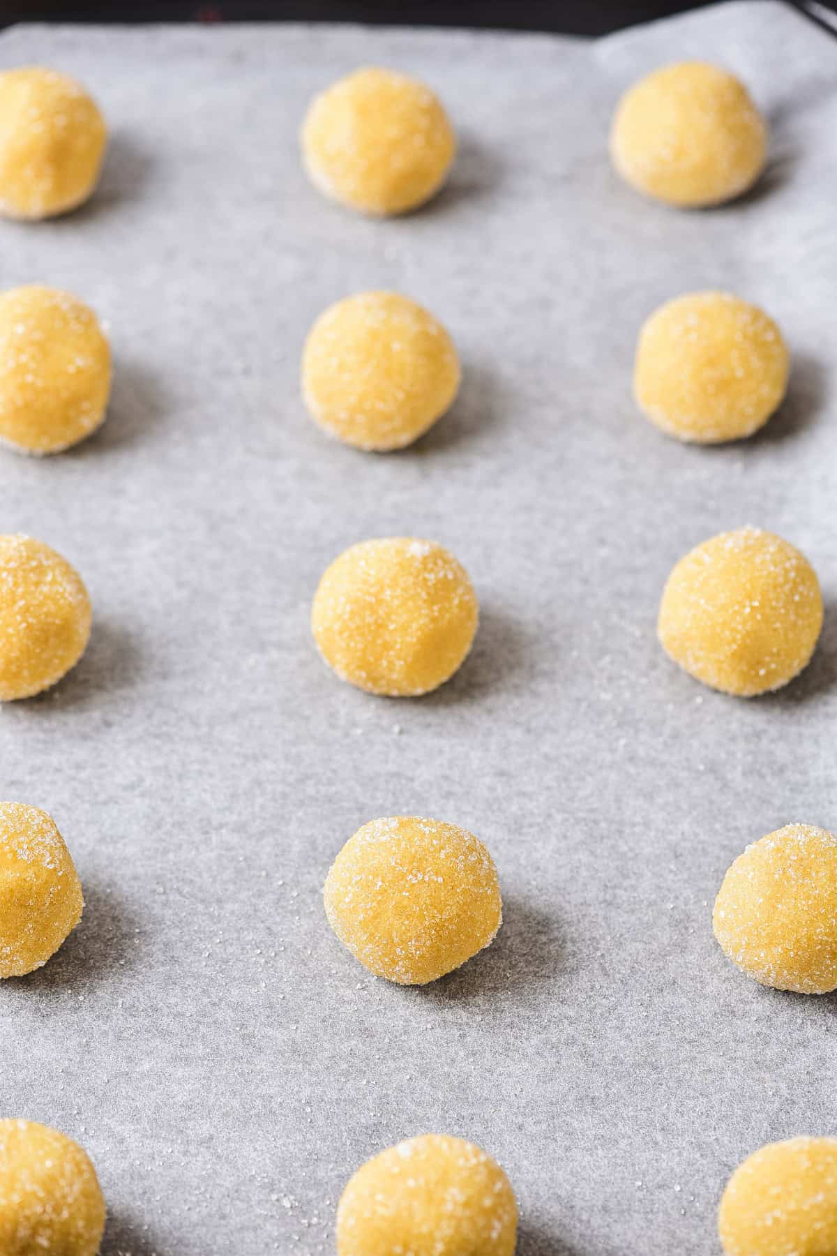 Round dough balls on a cookie sheet.