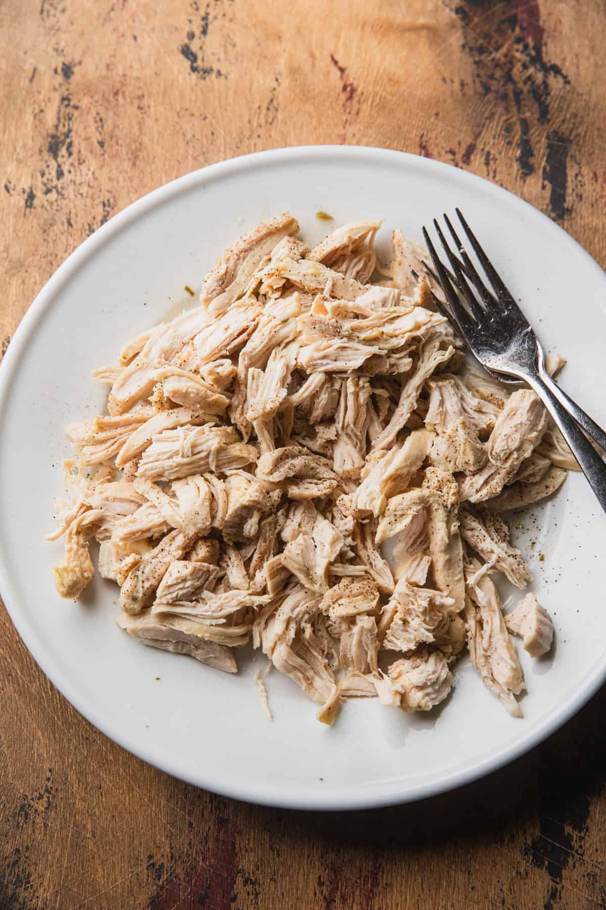 Shredding the chicken with two forks.