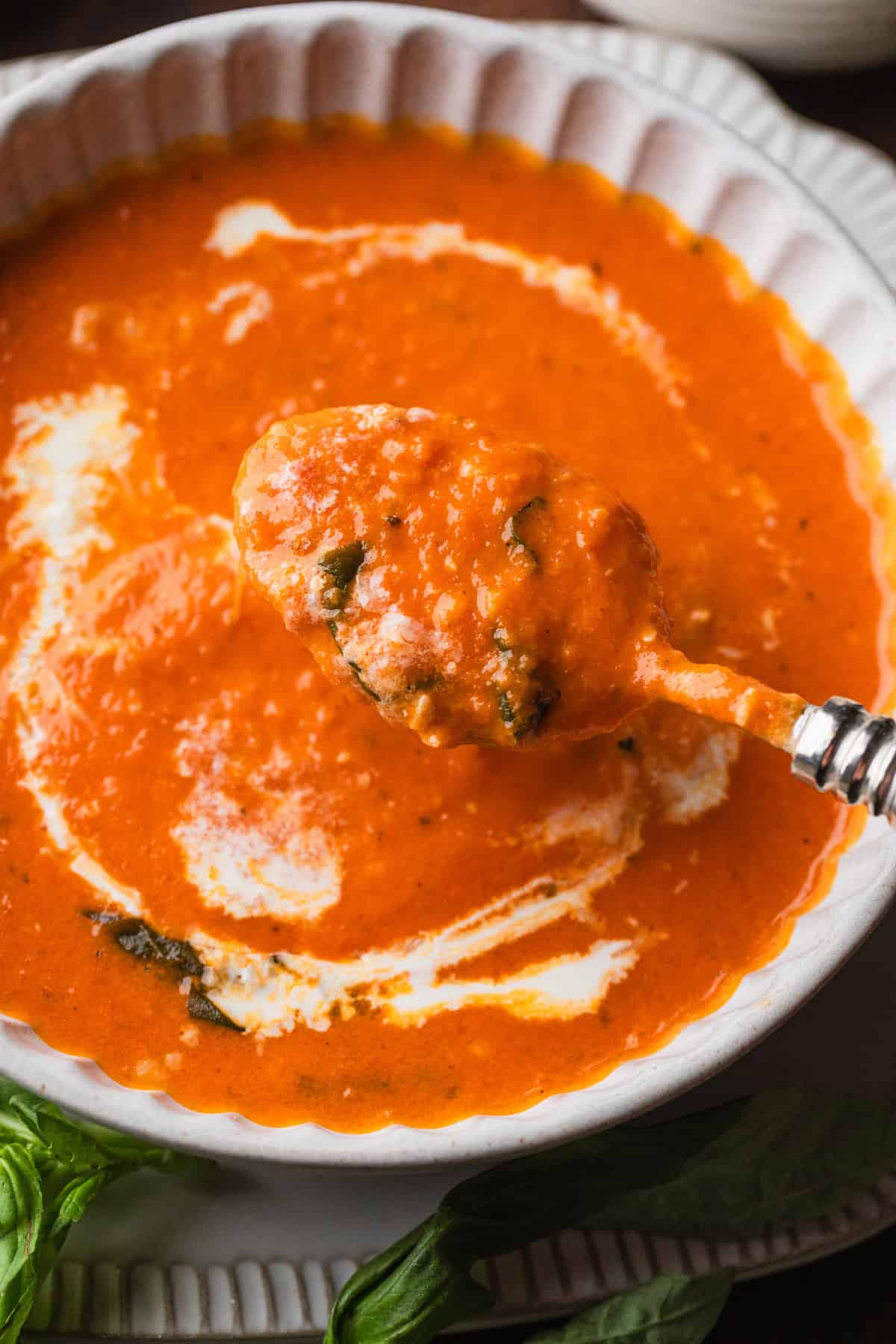 A spoonful ot tomato basil soup.