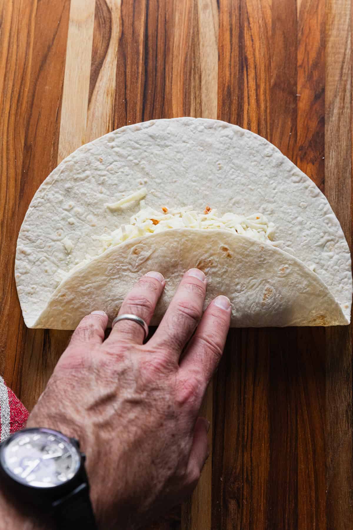 Folding tortilla to make a burrito.