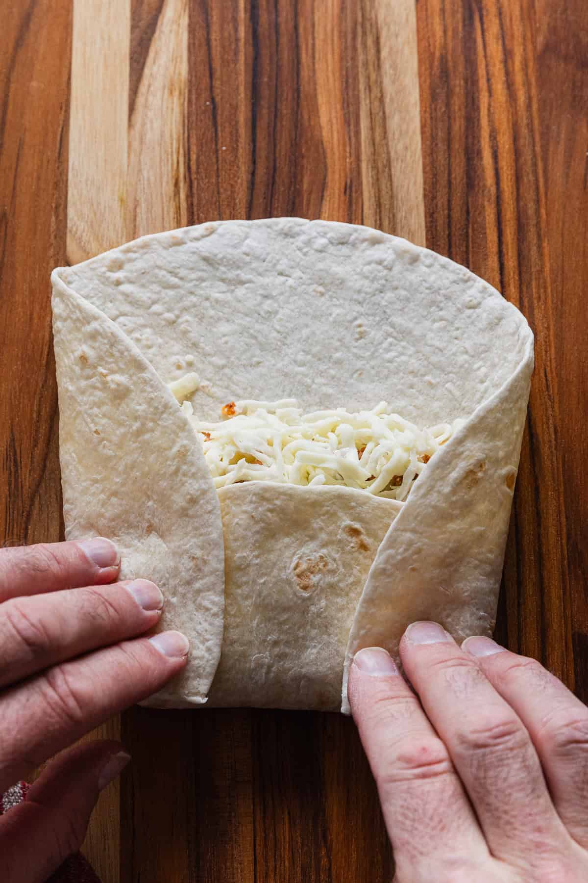 Folding tortilla to make a burrito.