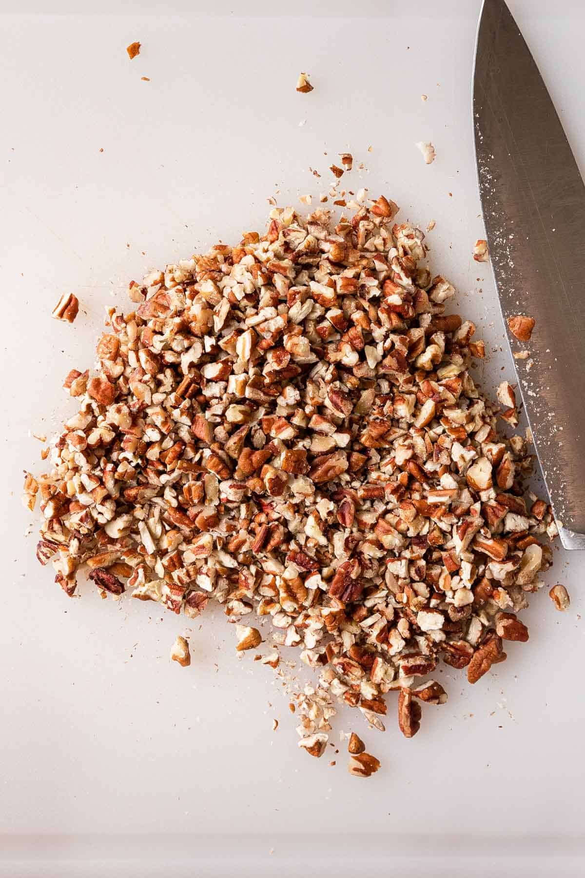 Chopped pecans on a cutting board.