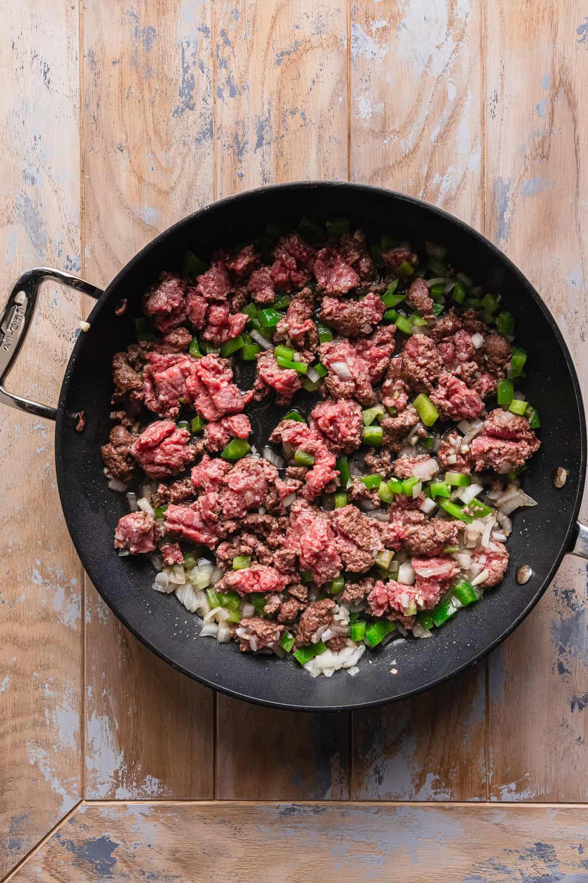 Cooking ground beef, onions, and green pepper.