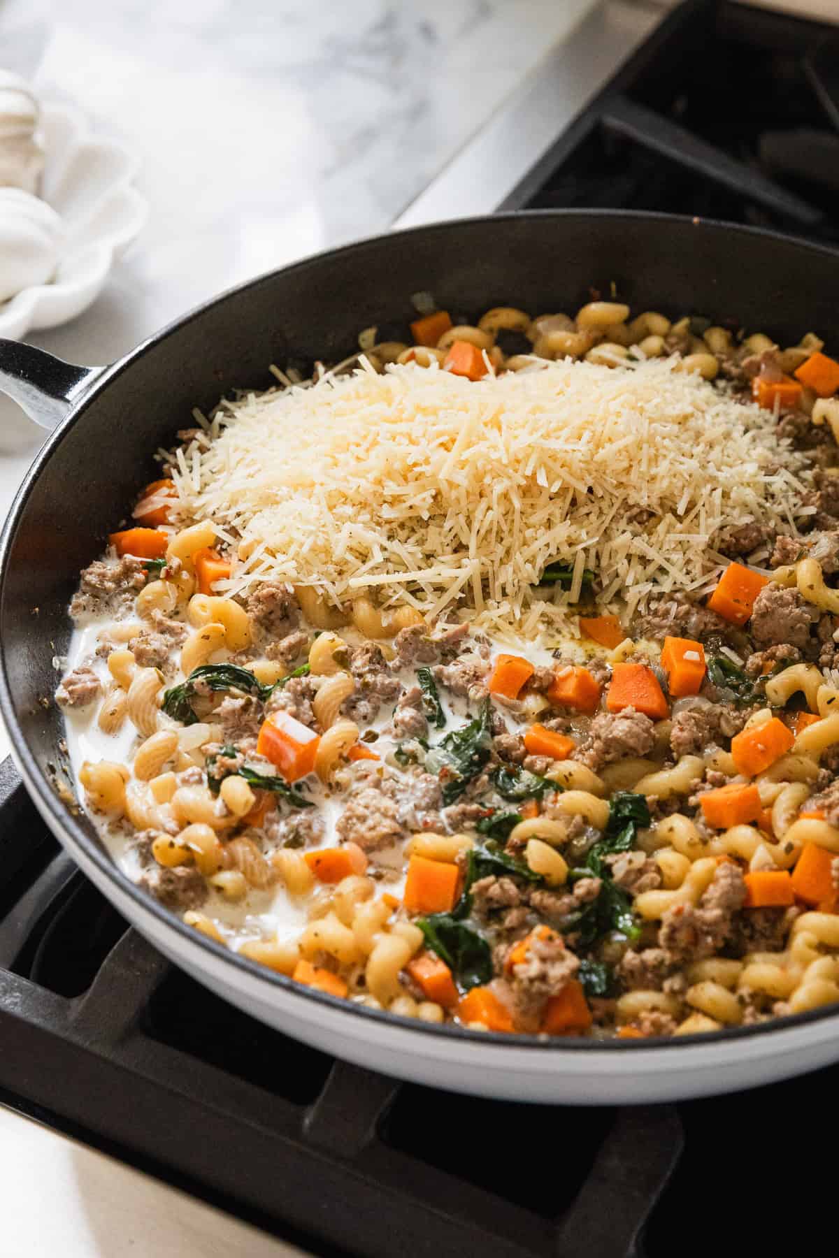 Add parmesan cheese and heavy cream to skillet.