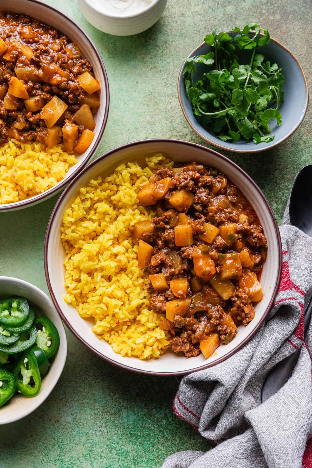 The completed Mexican beef and potatoes recipe with yellow rice in a serving bowl.