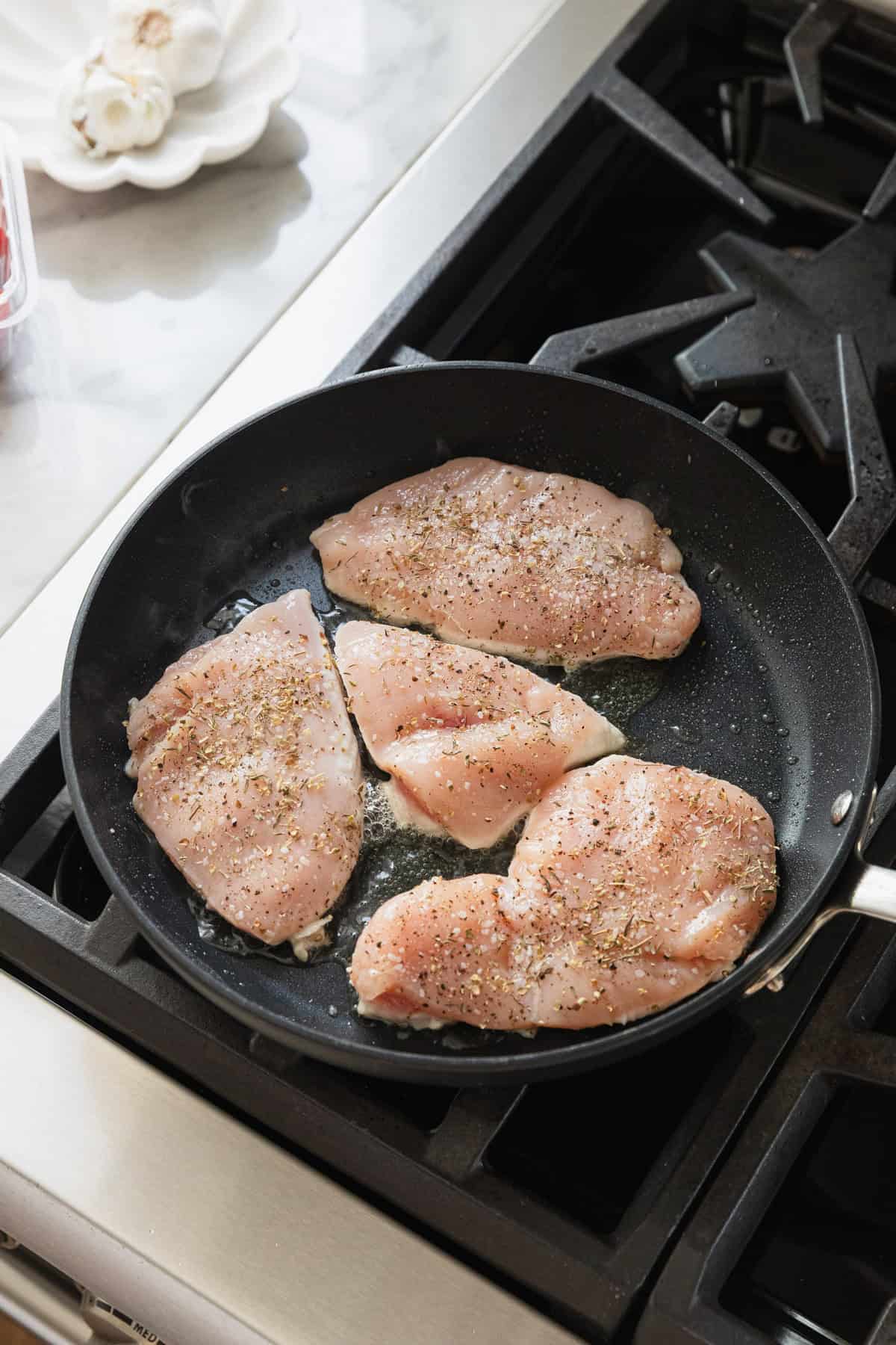 Cooking chicken breasts on the stovetop.