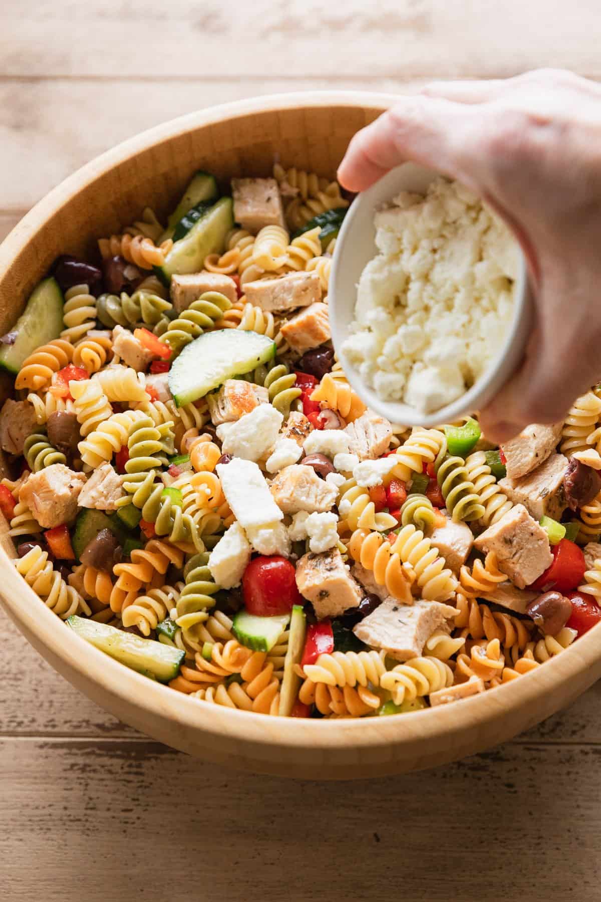 Adding crumbled feta cheese over the salad.